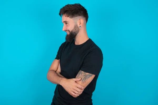 Jonge Spaanse Bebaarde Man Met Zwart Shirt Tegen Blauwe Achtergrond — Stockfoto