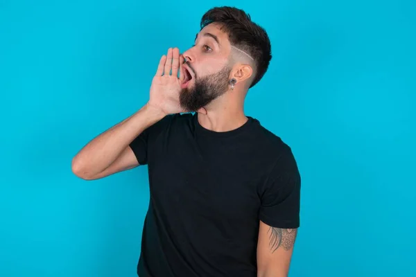 Spaanse Bebaarde Man Met Zwart Shirt Tegen Een Blauwe Achtergrond — Stockfoto
