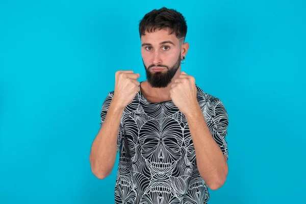 Displeased Annoyed Young Hispanic Bearded Man Standing Blue Background Clenches — Stock Photo, Image