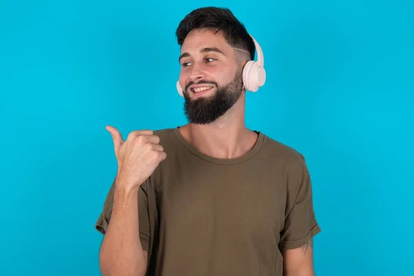 Young Hispanic Bearded Man Standing Blue Background Listens Audio Track — Stock Photo, Image