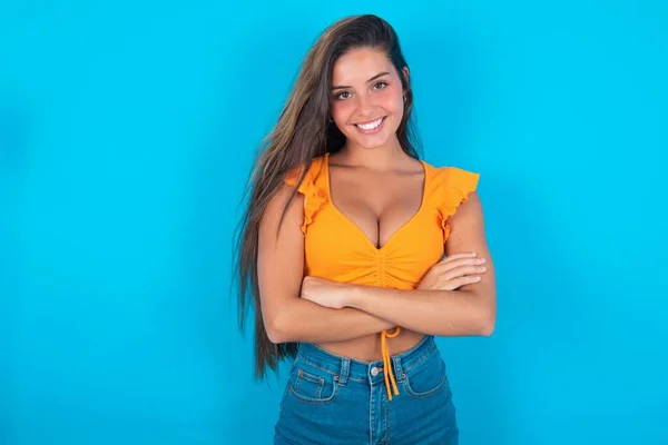 Mooie Brunette Vrouw Dragen Oranje Tank Top Blauwe Achtergrond Wordt — Stockfoto
