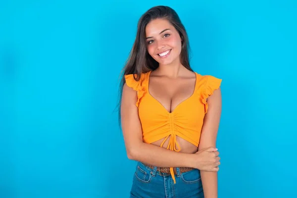Mooie Brunette Vrouw Dragen Oranje Tank Top Blauwe Achtergrond Lachen — Stockfoto