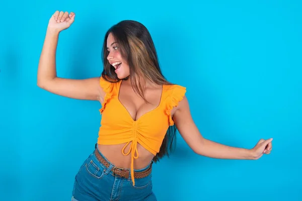 Mooie Brunette Vrouw Dragen Oranje Tank Top Blauwe Achtergrond Dansen — Stockfoto