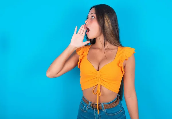 Hermosa Mujer Morena Vistiendo Camiseta Naranja Sobre Fondo Azul Vista — Foto de Stock