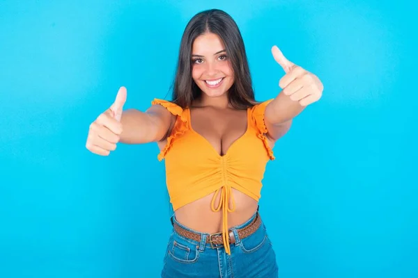 Bela Mulher Morena Vestindo Top Tanque Laranja Sobre Fundo Azul — Fotografia de Stock