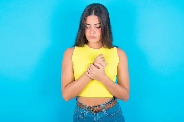 Droevige Mooie Brunette Vrouw Dragen Gele Tank Top Blauwe Achtergrond — Stockfoto