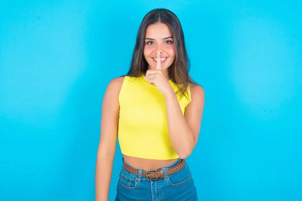 Lachende Mooie Brunette Vrouw Draagt Gele Tank Top Blauwe Achtergrond — Stockfoto