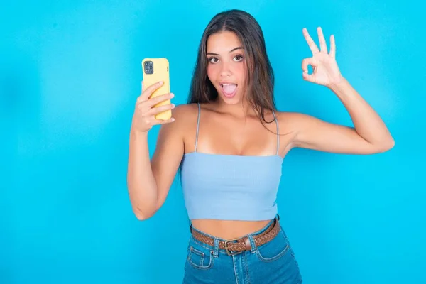 Vzrušená Žena Sobě Modrý Tank Top Ukazující Smartphone Prázdné Obrazovce — Stock fotografie