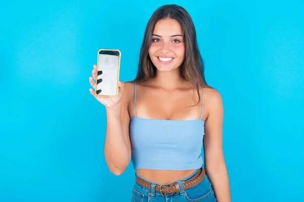 Sorrindo Jovem Morena Usando Top Tanque Azul Mostrando Tela Telefone — Fotografia de Stock