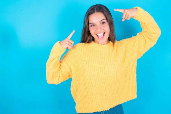 Vrolijke Jonge Brunette Vrouw Dragen Gele Trui Blauwe Achtergrond Demonstreren — Stockfoto