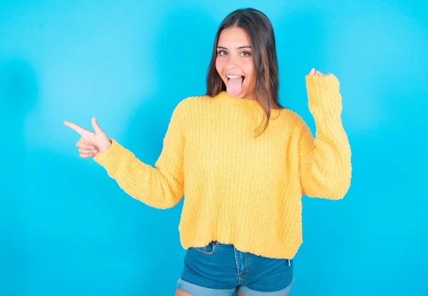 Young Brunette Woman Wearing Yellow Sweater Blue Background Points Empty — Stock Photo, Image