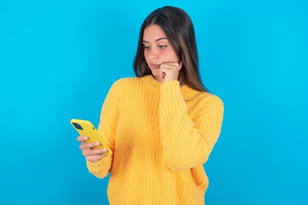 Jovem Morena Pensativa Usando Suéter Amarelo Sobre Fundo Azul Olhando — Fotografia de Stock