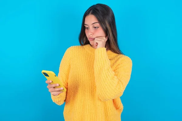 Bedachtzame Jonge Brunette Vrouw Dragen Van Gele Trui Blauwe Achtergrond — Stockfoto