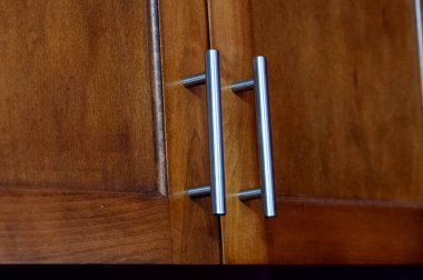 Önünde krom tutacakları olan mutfak dolaplarının ön cephesi