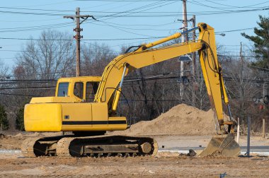 Sarı ağır traktörde çalışan kazıcı.