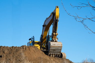 Toprak taşıma sırasında kum havuzunda kazıcı gökyüzü sarı kürek
