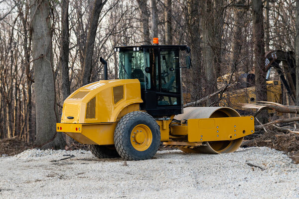 Желтый дорожный каток на ремонте дороги
