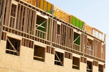 İnşaat iskeleti geliştirme duvarının altındaki yeni konut iskeleti.