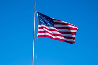 Mavi gökyüzüne karşı Amerikan bayrağı ulusal vatansever kızıl rüzgara karşı