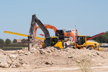 İnşaat ve yıkım sahasında endüstriyel hidrolik kazıcı, buldozer taşıyla inşaat atıklarının geri dönüşümü
