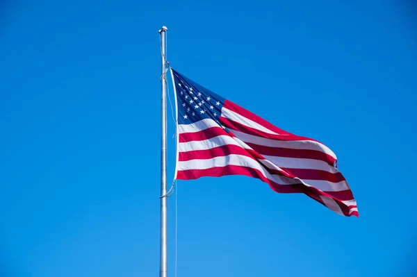 アメリカ国旗が青い空になびく — ストック写真