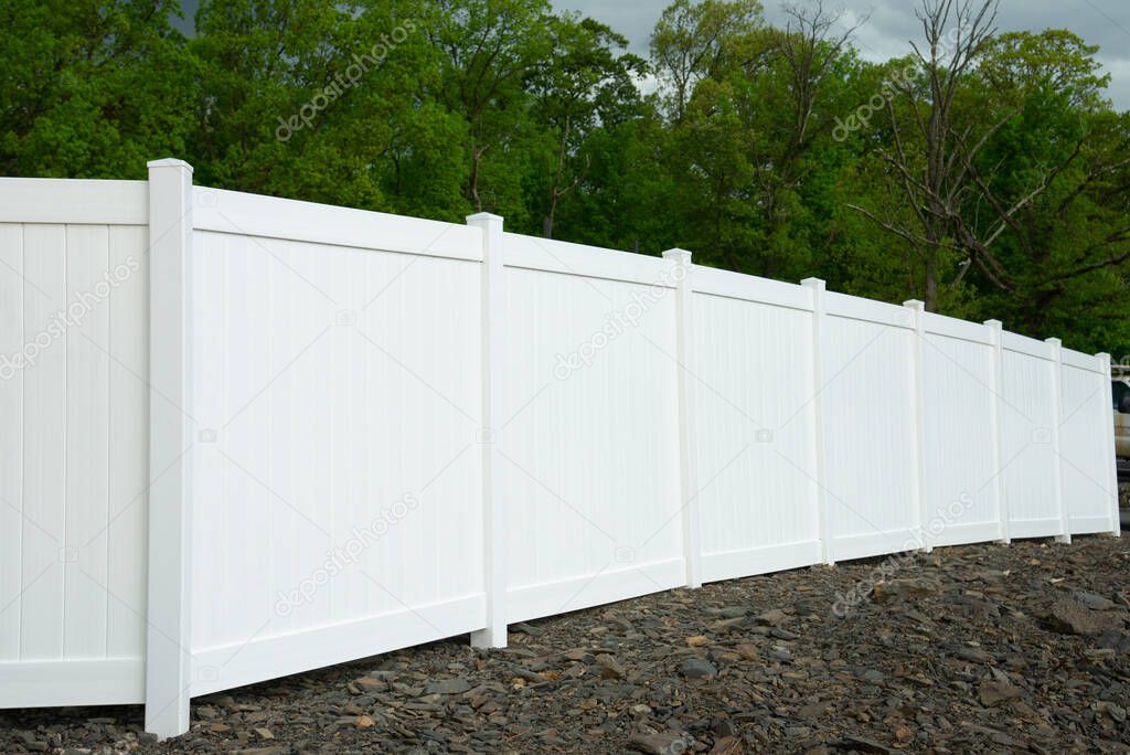 White vinyl fence fencing of private property grass plastic