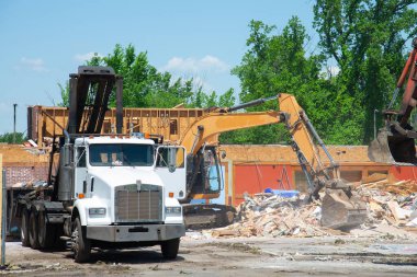 bulldozer loading demolition debris and concrete waste for recycling at construction site work stone dust