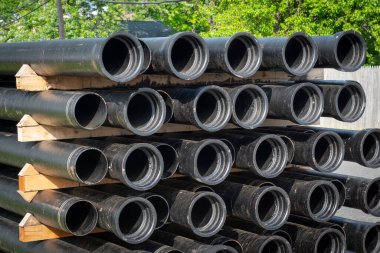 ceramics sewer pipes stacked on construction site drain black