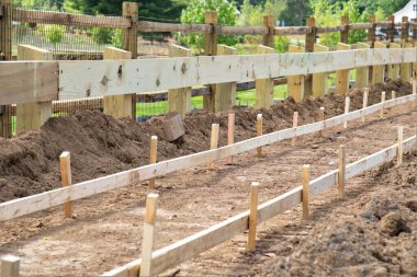 Bir kaldırım yapım aşamasında, beton kaldırım döşeniyor ve yolun temeli sokak taşı malzemesi hazırlanıyor.