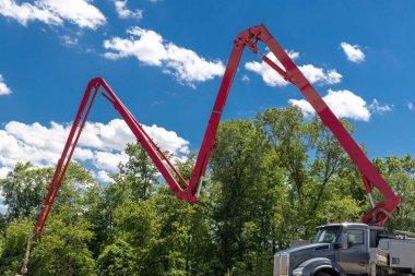 Kamyondan tüp takılmış beton pompalı inşaat işçisi. Formalite takviye kamyonuna çimento döküyor.