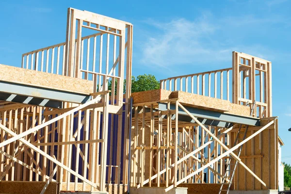 New residential construction home framing against a blue sky wooden construction plywood plank