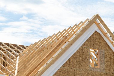 Wooden rafters against the blue sky in house under construction roofing wooden framework real plank