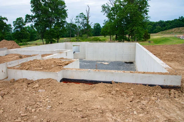 Poured concrete foundation for new house construction in suburban neighborhood cement work