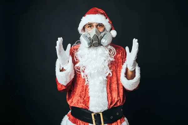 身穿圣诞老人服装 戴着碳过滤器面罩以避免感染病毒的人 背景是黑色的 圣诞观念 圣诞老人 庆祝活动 — 图库照片