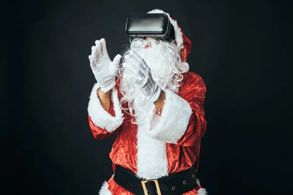 穿成圣诞老人的男人戴着一副虚拟现实的眼镜 背景是黑色的 圣诞老人 庆典的概念 — 图库照片