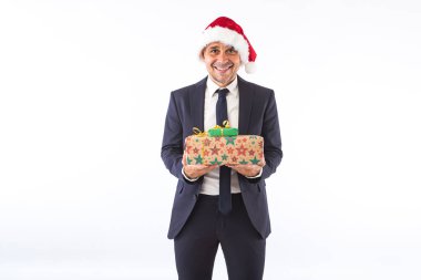 Takım elbiseli, kravatlı, Noel Baba şapkalı, gülümseyen, elinde beyaz arka planda iki hediye tutan bir iş adamı. Noel kutlaması kavramı.