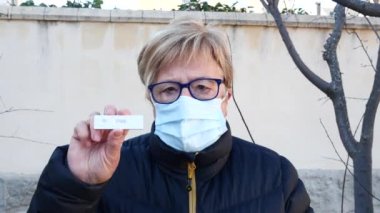 Sokaktaki yaşlı kadın, maske takıyor, antijen testi yaptırıyor. Kavram covid-19, ihu, delta, omicron, saptama testi ve pandemik.