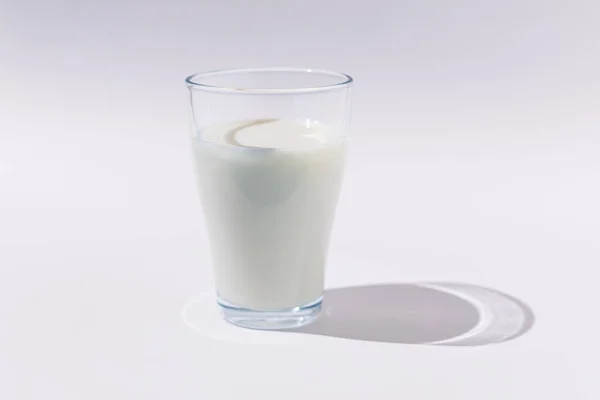 全玻璃杯牛奶在白色背景的硬光照下 生长和饮水概念 — 图库照片