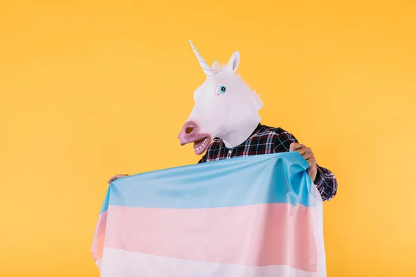 Osoba Ubrana Maskę Jednorożca Kratkę Flagą Kolektywu Transseksualistów Żółtym Tle — Zdjęcie stockowe