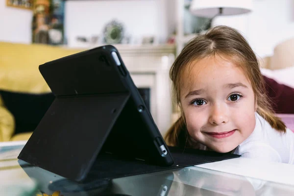 Uma Menina Loira Frente Tablet Olhando Para Câmera Sua Sala — Fotografia de Stock