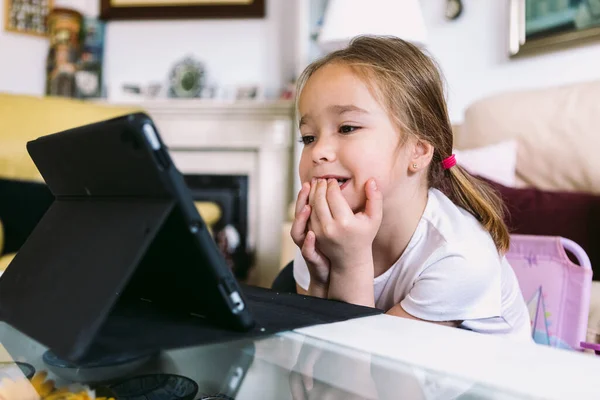 Uma Menina Loira Assistindo Atentamente Vídeo Tablet Sua Sala Estar — Fotografia de Stock