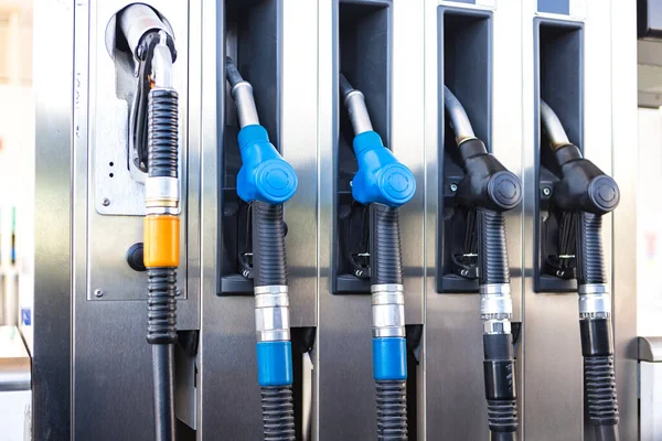 Five black, blue and orange fuel hoses at a gas station. Concept of gasoline, diesel, liquefied gas, LPG, gallon, super, crisis, expensive and transportation.