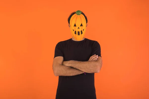 Osoba Masce Dyni Świętującej Halloween Krzyżowanymi Ramionami Pomarańczowym Tle Koncepcja — Zdjęcie stockowe