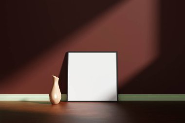 Kare siyah poster ya da fotoğraf çerçevesi. Ahşap zeminde vazo var. Odanın duvarına yaslanmış, gölgeli.