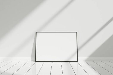 Minimalist ve temiz yatay siyah poster ya da fotoğraf çerçevesi zemin üzerinde gölgeli duvara yaslanmış.