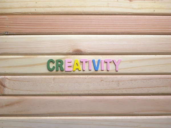 Word Creativity on wood background