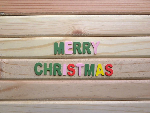 Word Merry Christmas on wood background
