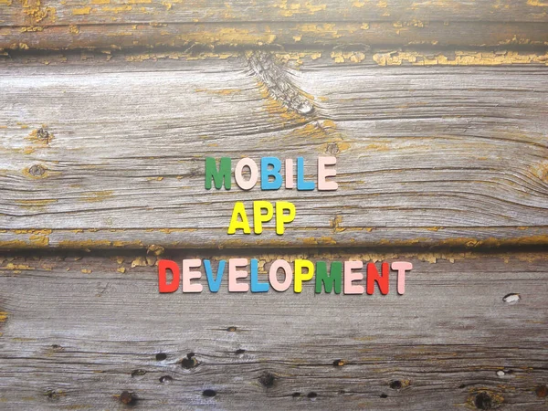 Words Mobile app development on wood background
