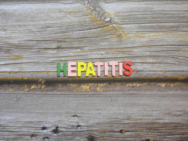Word Hepatitis on wood background