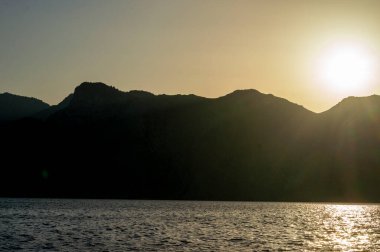 Ege Denizi 'ndeki Yunan adaları üzerinde batmış bir deniz manzarası. Tepelerin silueti